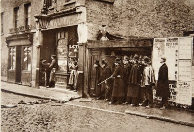 Om de hoek glurend, stelde hij zich bloot aan het willekeurige vuur van de belegerde inbrekers: de heer Winston Churchill met hoge hoed in East End van Londen, tijdens het Sidney Street Drama door English Photographer